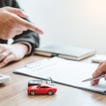 Somebody signing paperwork related to a new car warranty