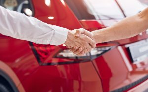People shaking hands showing that they have reached an agreement regarding car ownership