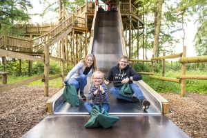 A family and children enjoying a slide on a fun family day out