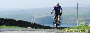 A man riding a bike past daffodils